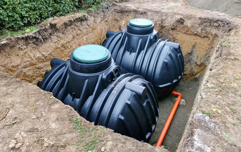 Onsite septic system tanks being installed in an excavation